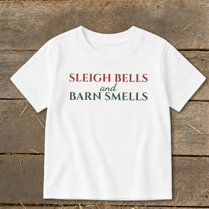 White t-shirt with "Sleigh Bells and Barn Smells" text in red and green.