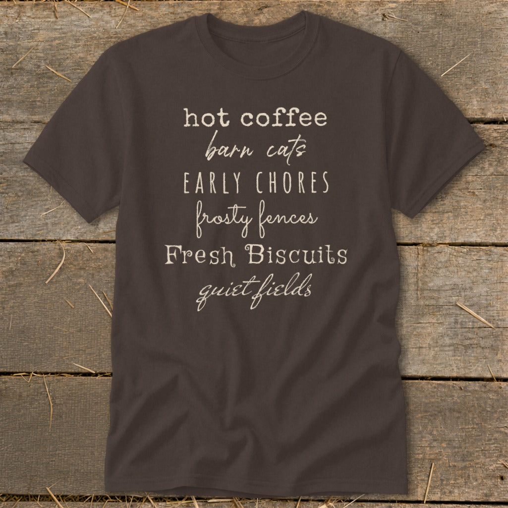 Brown t-shirt with white text: hot coffee, barn cats, early chores, frosty fences, fresh biscuits, quiet fields.