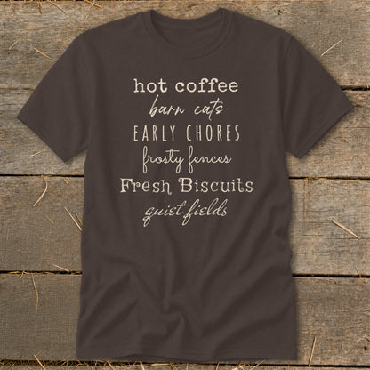 Brown t-shirt with white text: hot coffee, barn cats, early chores, frosty fences, fresh biscuits, quiet fields.