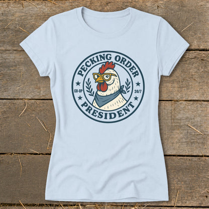 Light blue t-shirt with a circular graphic of a rooster wearing glasses and a bandana, reading "Pecking Order President"