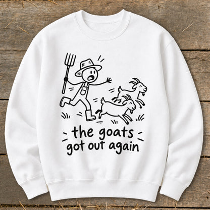 White sweatshirt with black illustration of farmer chasing goats with text "the goats got out again".
