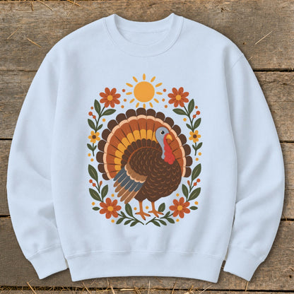 Light blue sweatshirt with a stylized turkey, sun, and floral border design.