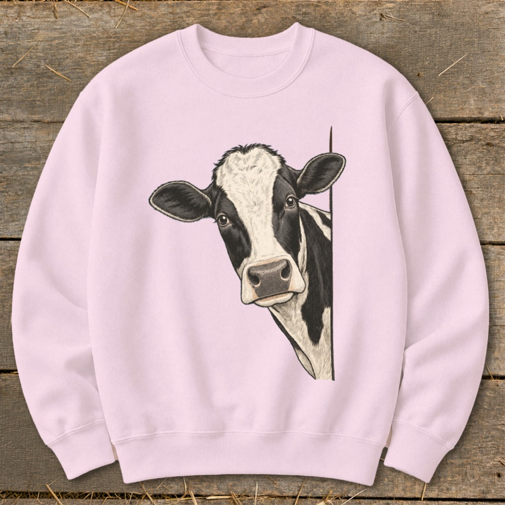 Pink crewneck sweatshirt with a black and white cow peeking from the side.