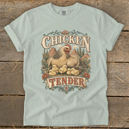 Light blue t-shirt with "Chicken Tender" text and hen with chicks in a desert scene.