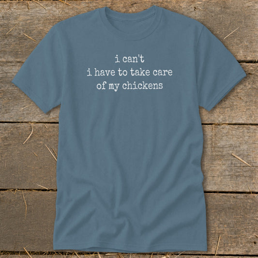Blue t-shirt with white text reading "i can't i have to take care of my chickens".