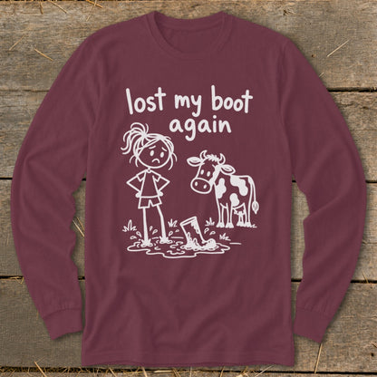 Maroon long-sleeve t-shirt with a white stick-figure graphic of a girl and cow looking at a muddy boot, with text reading lost my boot again.