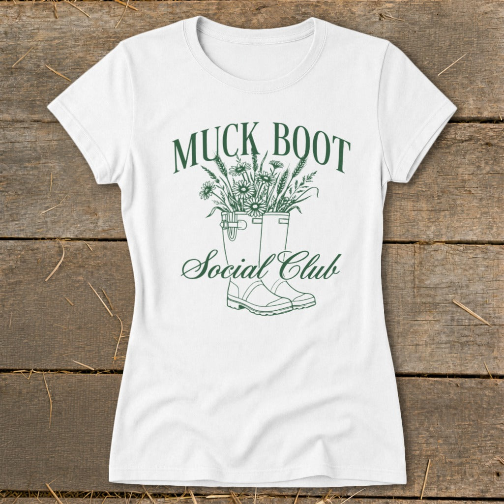 White t-shirt with "MUCK BOOT Social Club" text and floral boot design.
