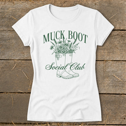 White t-shirt with "MUCK BOOT Social Club" text and floral boot design.