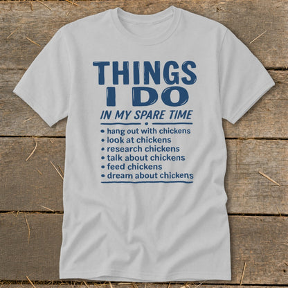 White t-shirt with blue text listing chicken-related activities for spare time.