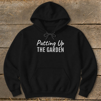 Black hoodie with white text "Putting Up THE GARDEN" on the front.