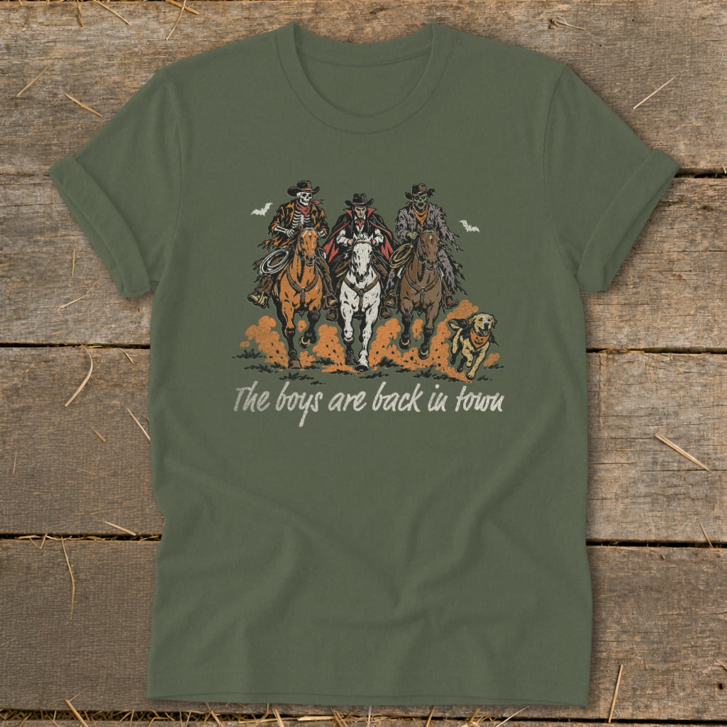 T-shirt with three skeleton cowboys riding horses and a dog, text reads "The boys are back in town".