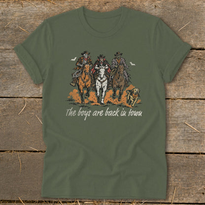 T-shirt with three skeleton cowboys riding horses and a dog, text reads "The boys are back in town".