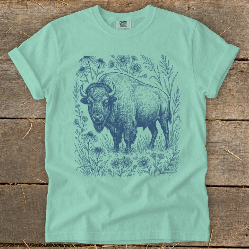 Mint green t-shirt with a blue ink drawing of a bison surrounded by wildflowers.