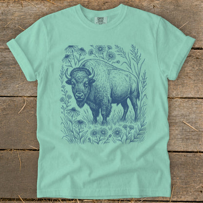 Mint green t-shirt with a blue ink drawing of a bison surrounded by wildflowers.