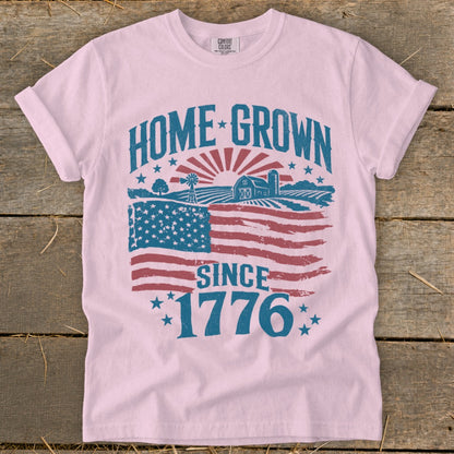 Pink t-shirt with "Home Grown Since 1776" text and a farm scene USA flag graphic.