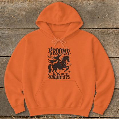 Orange hoodie with black graphic of a witch riding a horse and text.