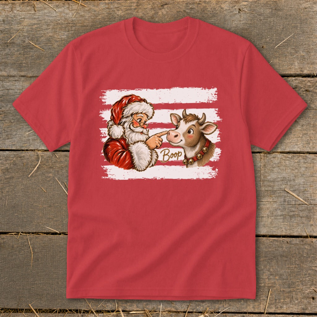 Santa Claus playfully boops a cow's nose with the word "Boop" on a red t-shirt.