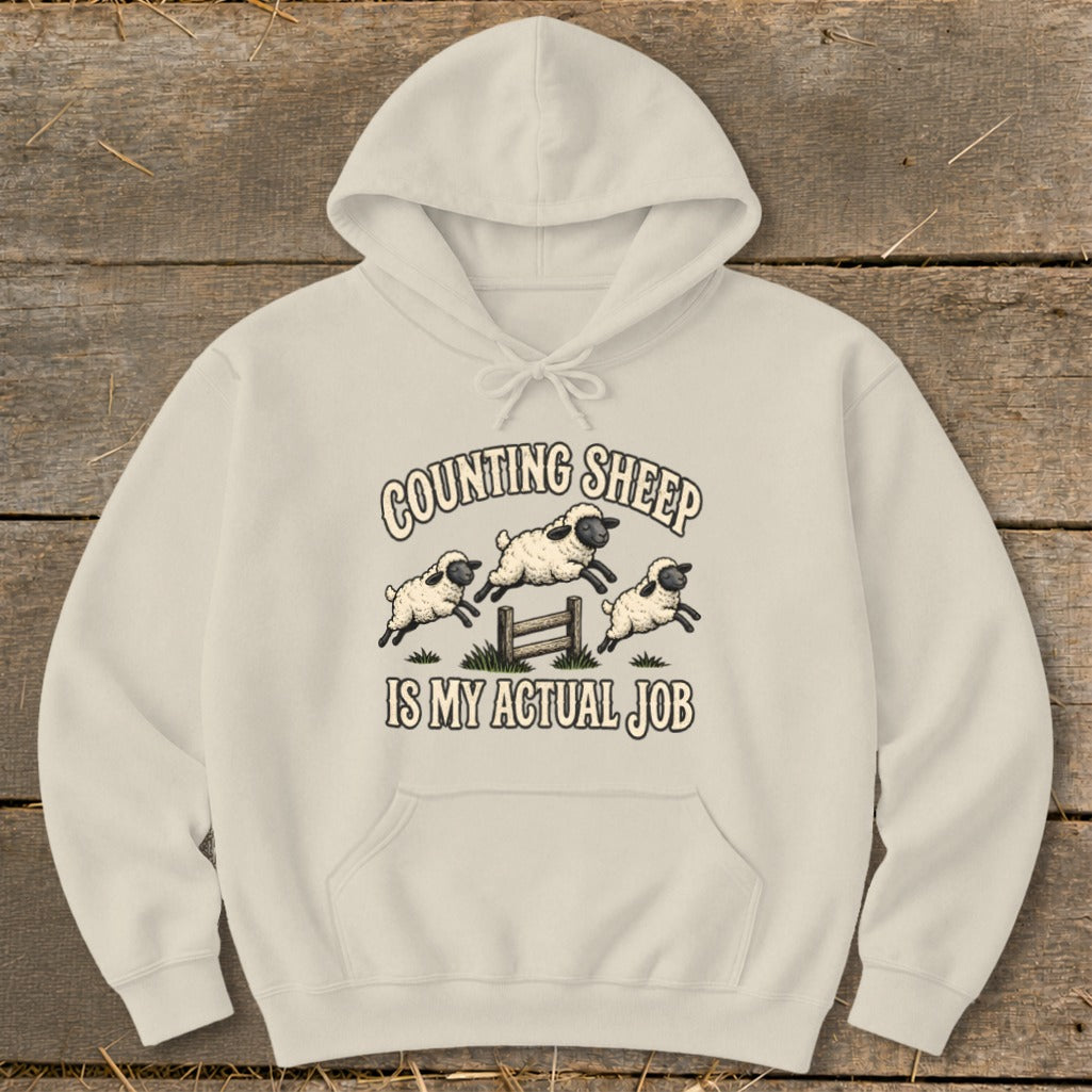 Cream hoodie with "Counting Sheep Is My Actual Job" text and jumping sheep graphic.