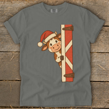 Cow wearing Santa hat peeking from behind barn door with "COMFORT COLORS" tag.