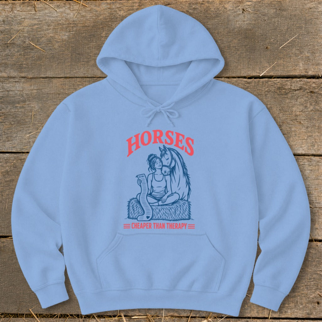 Light blue hoodie with a graphic of a woman and horse, text reads "HORSES CHEAPER THAN THERAPY".