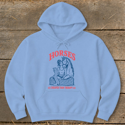 Light blue hoodie with a graphic of a woman and horse, text reads "HORSES CHEAPER THAN THERAPY".