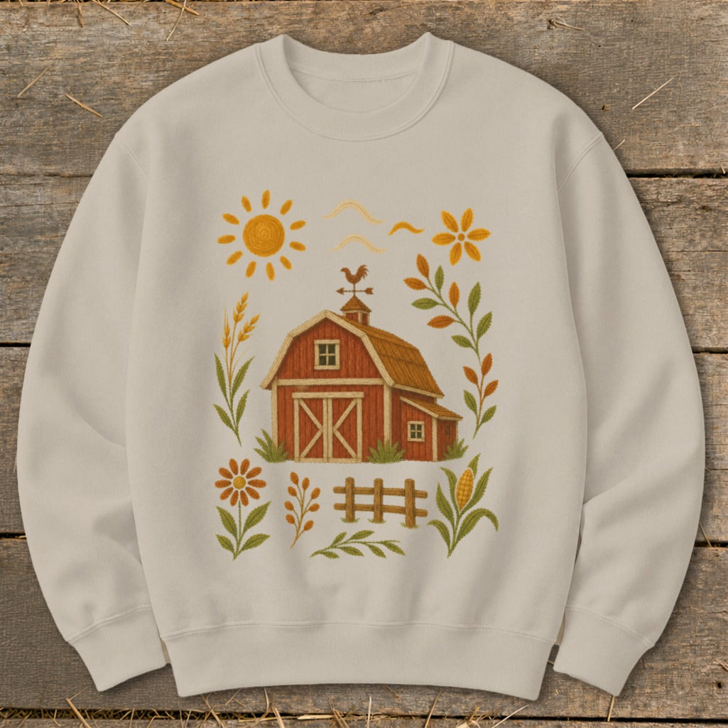 Cream sweatshirt with a red barn and farm scene graphic design.