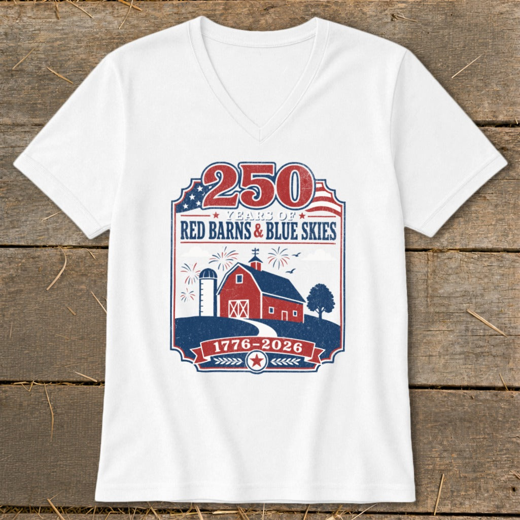 White V-neck t-shirt with patriotic "250 Years of Red Barns & Blue Skies 1776-2026" graphic.