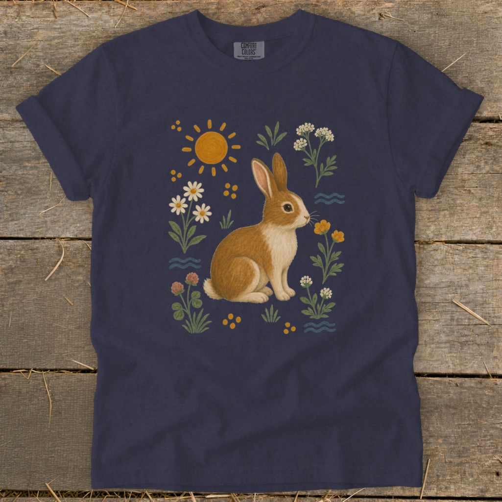Navy t-shirt with a brown rabbit surrounded by flowers, sun, and water elements.
