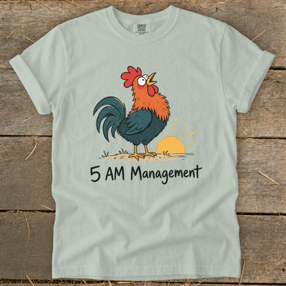 Light blue t-shirt with a rooster crowing at sunrise, text "5 AM Management".