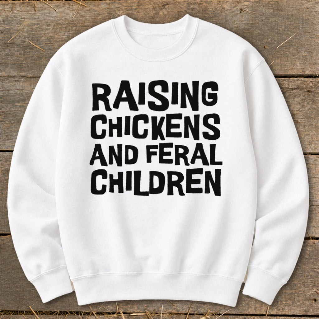 White sweatshirt with black text reading "Raising Chickens and Feral Children."