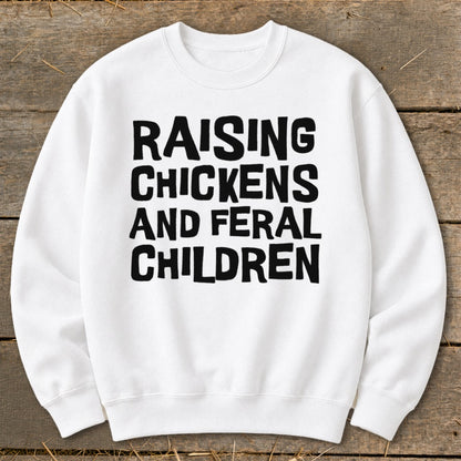 White sweatshirt with black text reading "Raising Chickens and Feral Children."