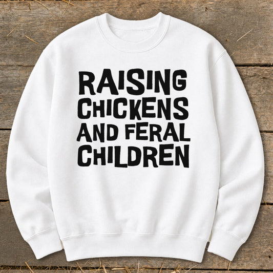 White sweatshirt with black text reading "Raising Chickens and Feral Children."