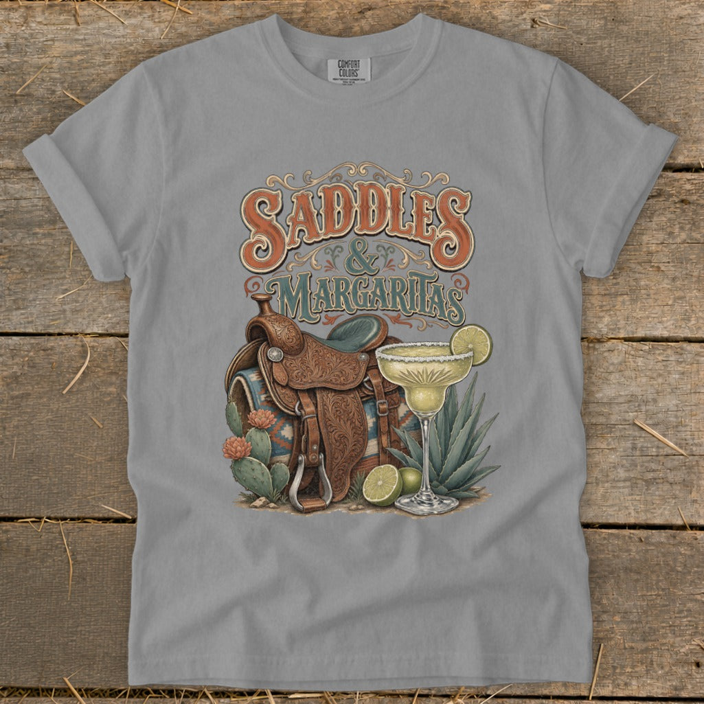 T-shirt graphic with "Saddles & Margaritas" text, western saddle, margarita, and cacti.