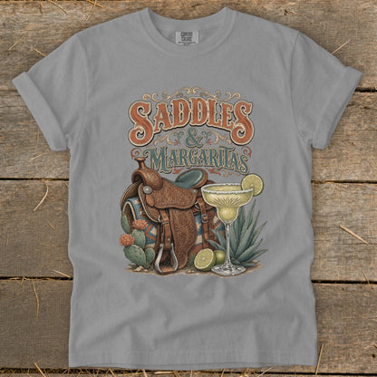 T-shirt graphic with "Saddles & Margaritas" text, western saddle, margarita, and cacti.