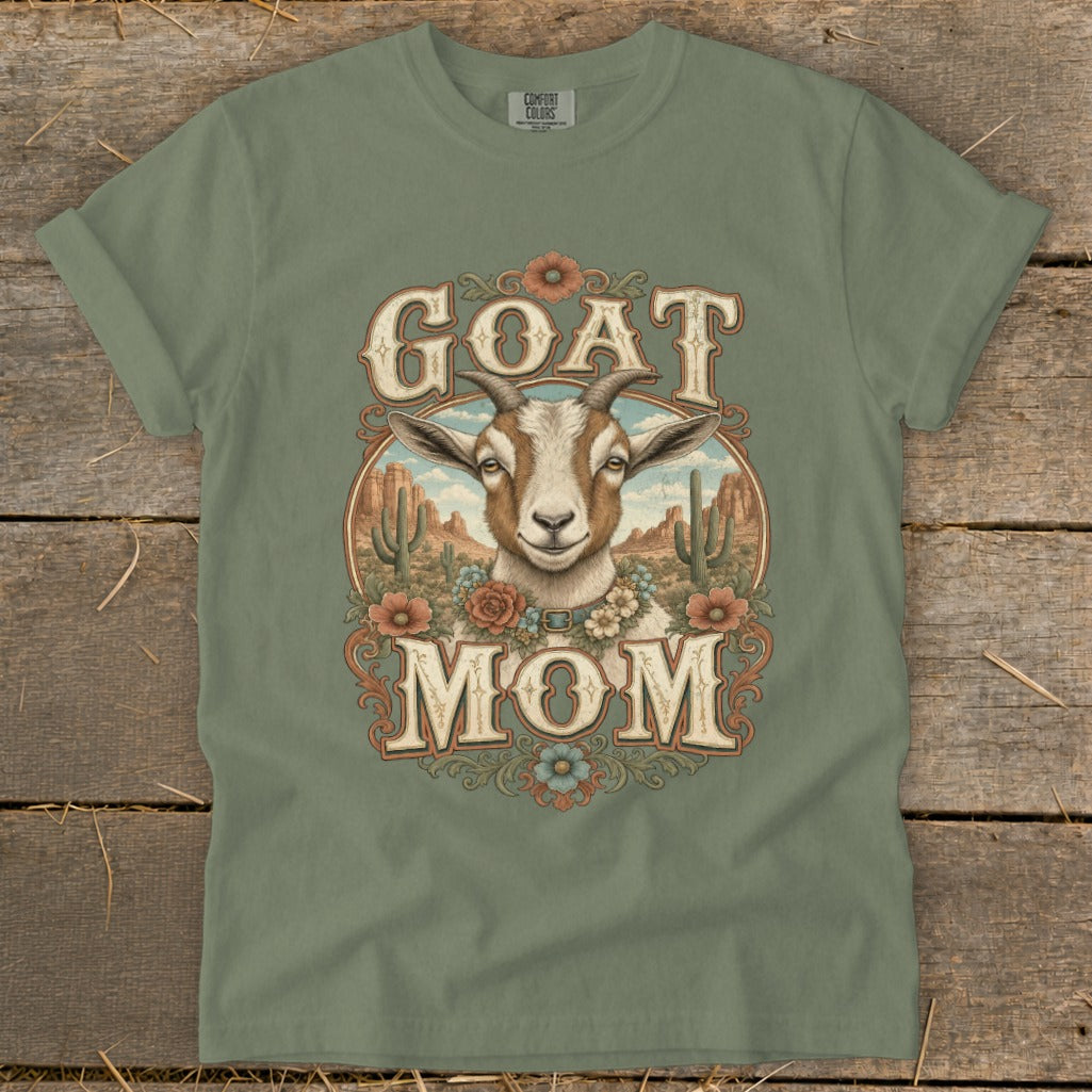 T-shirt graphic with text "GOAT MOM" and a goat in a desert scene.