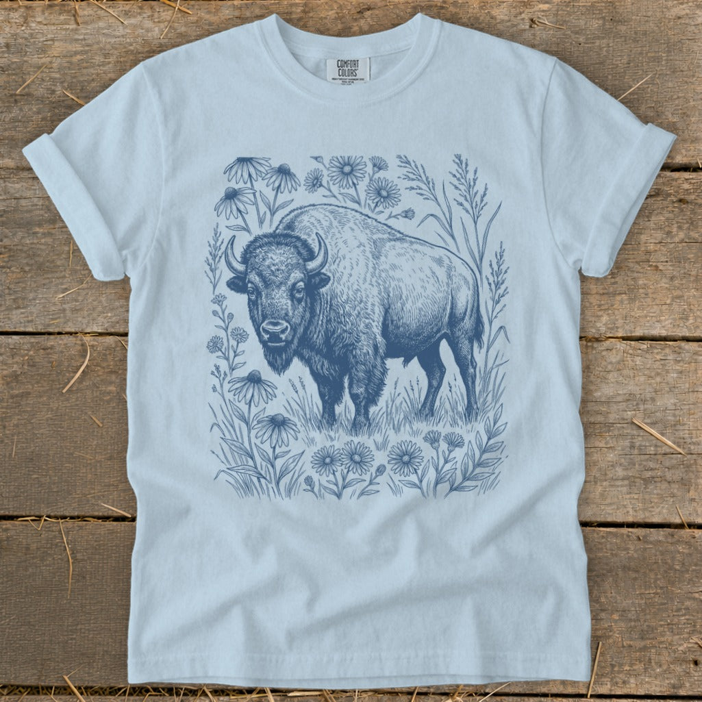 Light blue t-shirt with a detailed blue ink drawing of a bison surrounded by wildflowers.