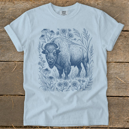 Light blue t-shirt with a detailed blue ink drawing of a bison surrounded by wildflowers.