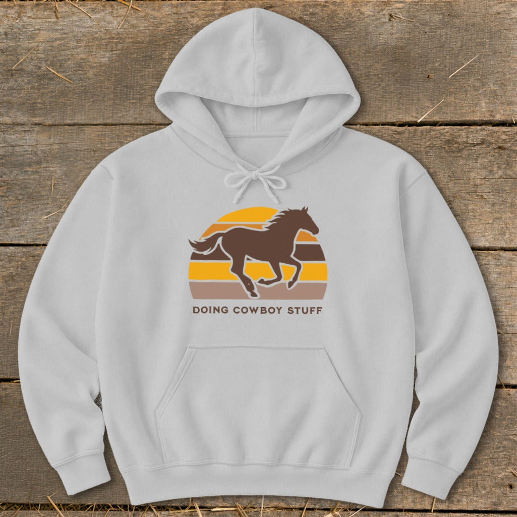 Light grey hoodie with brown running horse graphic and "Doing Cowboy Stuff" text.