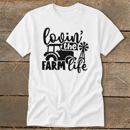 White t-shirt with black graphic of tractor, windmill, and text "lovin' the FARM life".