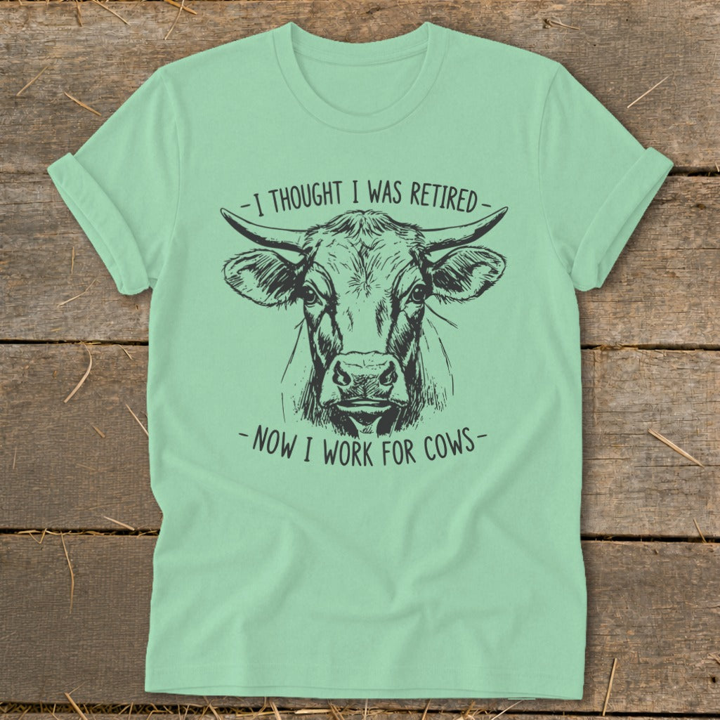 Mint t-shirt with black ink drawing of a cow's head and text.