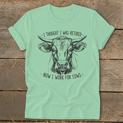 Mint t-shirt with black ink drawing of a cow's head and text.