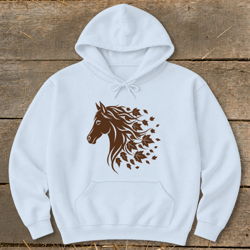 White hoodie with a brown horse head graphic transitioning into autumn leaves.
