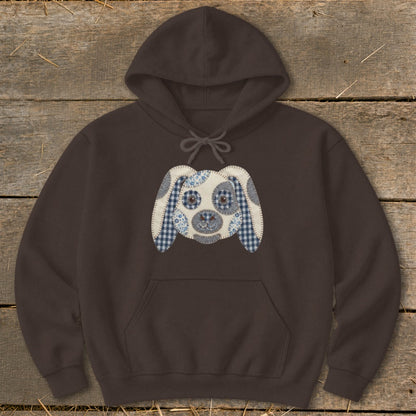 Brown hoodie with a patchwork dog face applique on the chest.