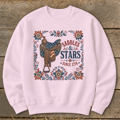 Pink sweatshirt with "Saddles & Stars Since 1776" graphic and western saddle.