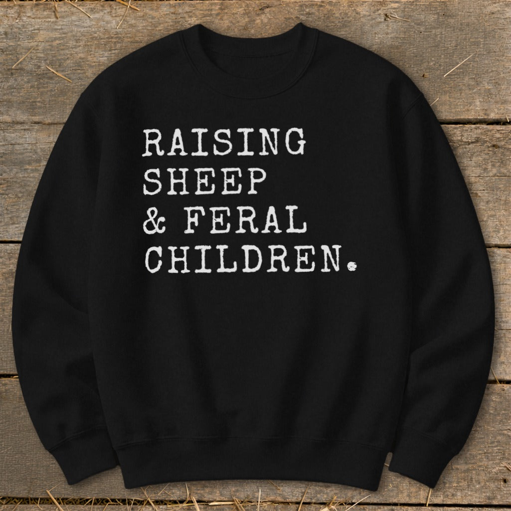 Black sweatshirt with white text reading "RAISING SHEEP & FERAL CHILDREN."