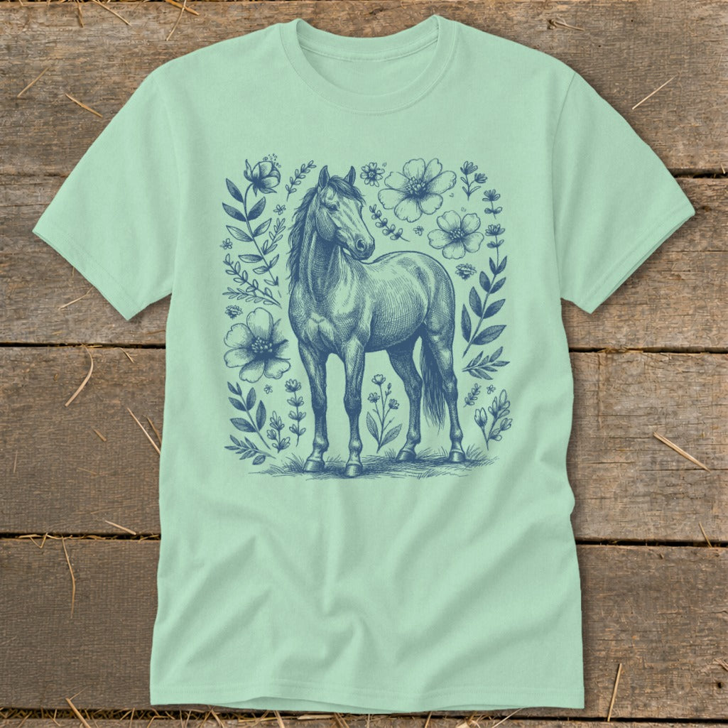 Light green t-shirt with a dark blue sketch of a horse surrounded by flowers.