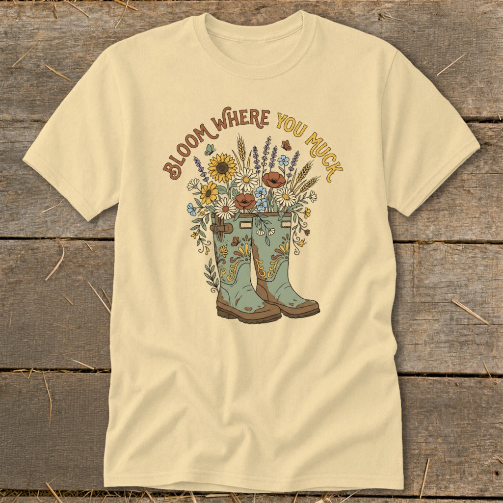 Cream t-shirt with "Bloom Where You Muck" and floral boots graphic.