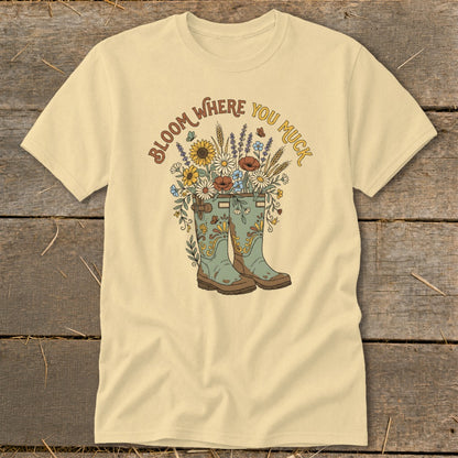 Cream t-shirt with "Bloom Where You Muck" and floral boots graphic.