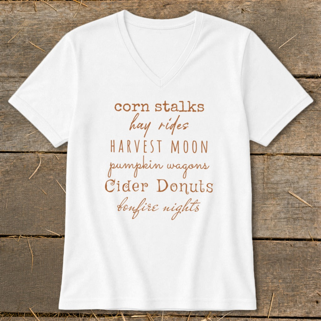 White V-neck t-shirt with "corn stalks, hay rides, HARVEST MOON, pumpkin wagons, Cider Donuts, bonfire nights" text.
