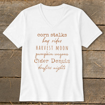 White V-neck t-shirt with "corn stalks, hay rides, HARVEST MOON, pumpkin wagons, Cider Donuts, bonfire nights" text.